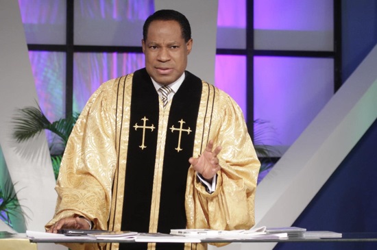 Pastor Chris Oyakhilome stands on a stage with a desk in front of him, explaining his divorce.